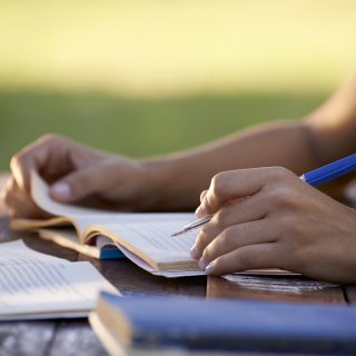 Young people and education, woman studying for university test Young women and education, close up of hands of girl studying for college exam in park. Side view, copy space